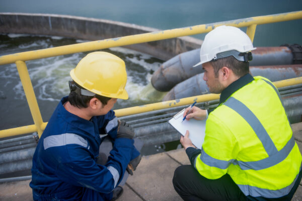 Ingénieur environnement réalisant un prélèvement d’eau en station